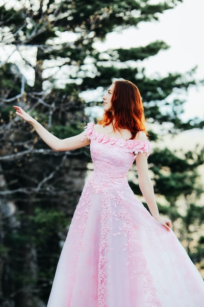 白天站在森林里的穿粉红色衣服的女孩